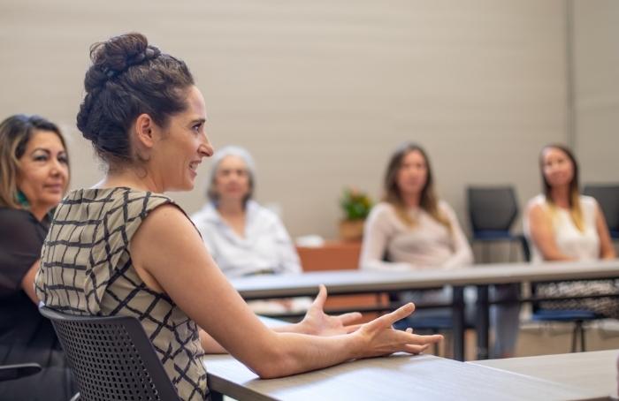 Community member, Kelly Almeida, and classmates discuss business planning in a WEV business class.