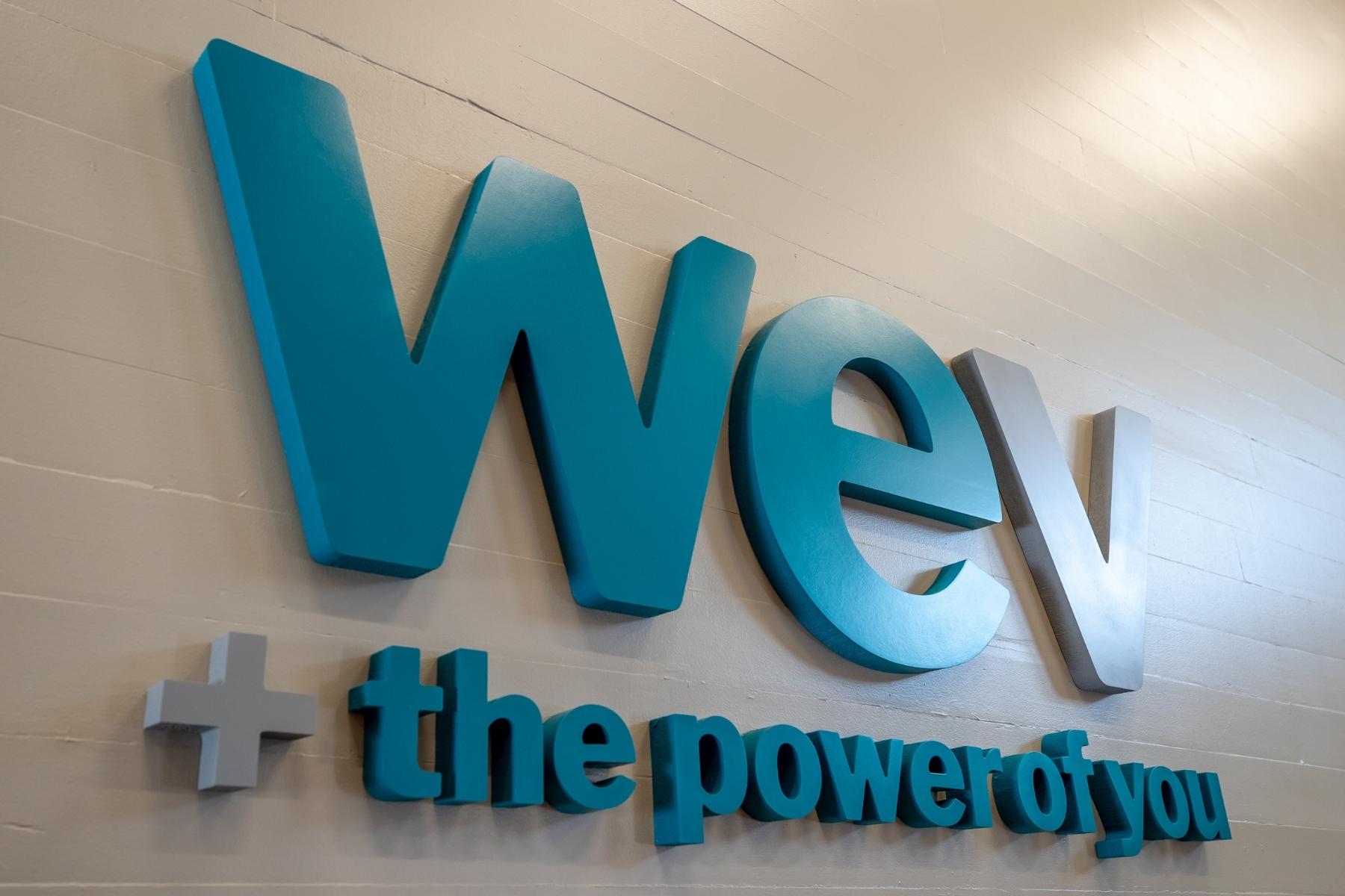 Logo on the wall in the Santa Barbara Community Center states WEV + the Power of You