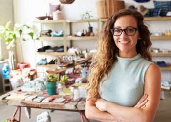 La dueña de un negocio sonríe en su tienda después de usar una buena deuda para hacer crecer su negocio